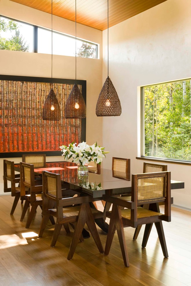 Immagine di una sala da pranzo minimal con pareti beige e parquet scuro