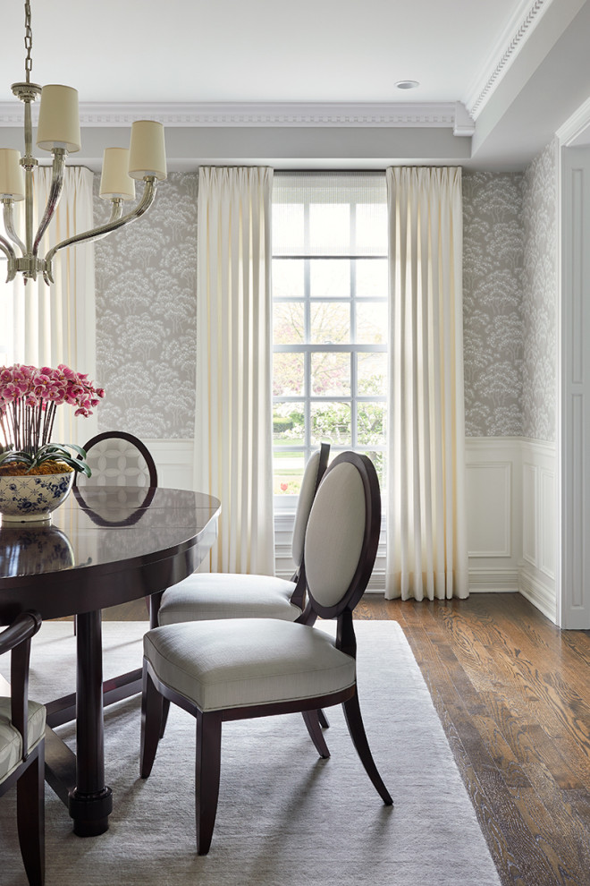 Imagen de comedor clásico con paredes grises, suelo de madera en tonos medios, suelo marrón, bandeja y papel pintado