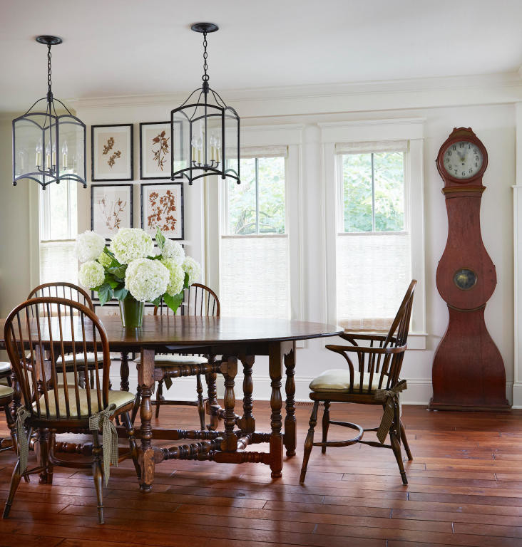 Immagine di una sala da pranzo aperta verso la cucina tradizionale di medie dimensioni con pareti bianche, parquet scuro, camino classico, cornice del camino in legno e pavimento marrone