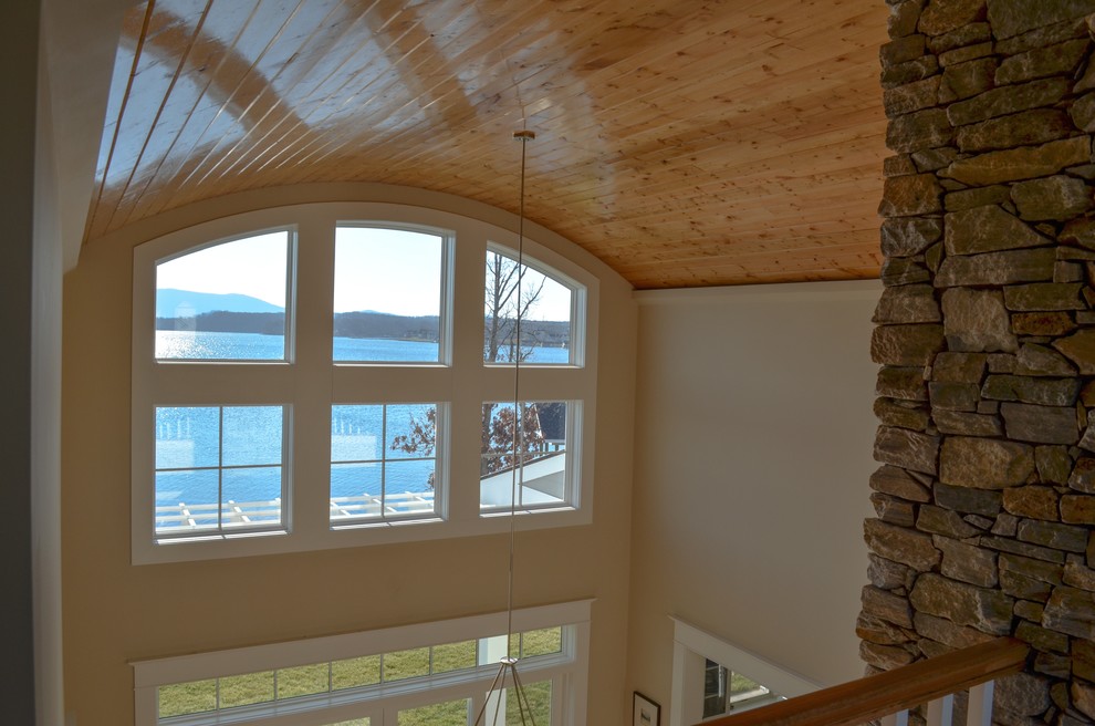 Exemple d'une grande salle à manger ouverte sur le salon bord de mer avec parquet clair, une cheminée standard et un manteau de cheminée en pierre.