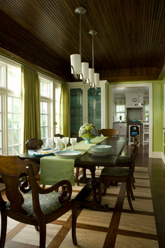 Large nautical enclosed dining room in Other with green walls, dark hardwood flooring and brown floors.