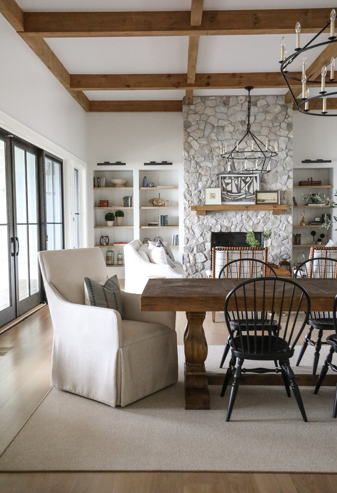 Ispirazione per una sala da pranzo aperta verso il soggiorno costiera con pareti bianche, pavimento in legno massello medio e pavimento marrone
