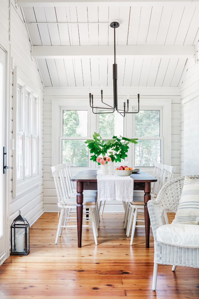 Foto di una piccola sala da pranzo stile marino con pareti bianche, pavimento in legno massello medio e pavimento marrone