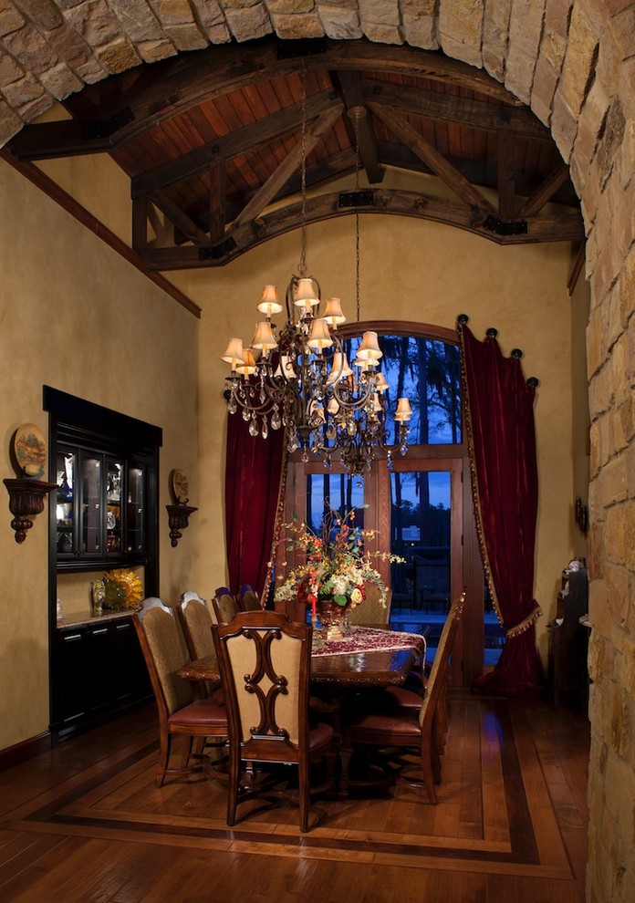 Example of a large tuscan medium tone wood floor kitchen/dining room combo design in Tampa with beige walls and no fireplace
