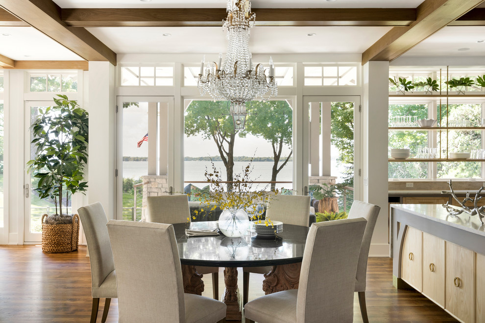 Immagine di una sala da pranzo aperta verso la cucina country con pareti bianche, pavimento in legno massello medio e pavimento marrone