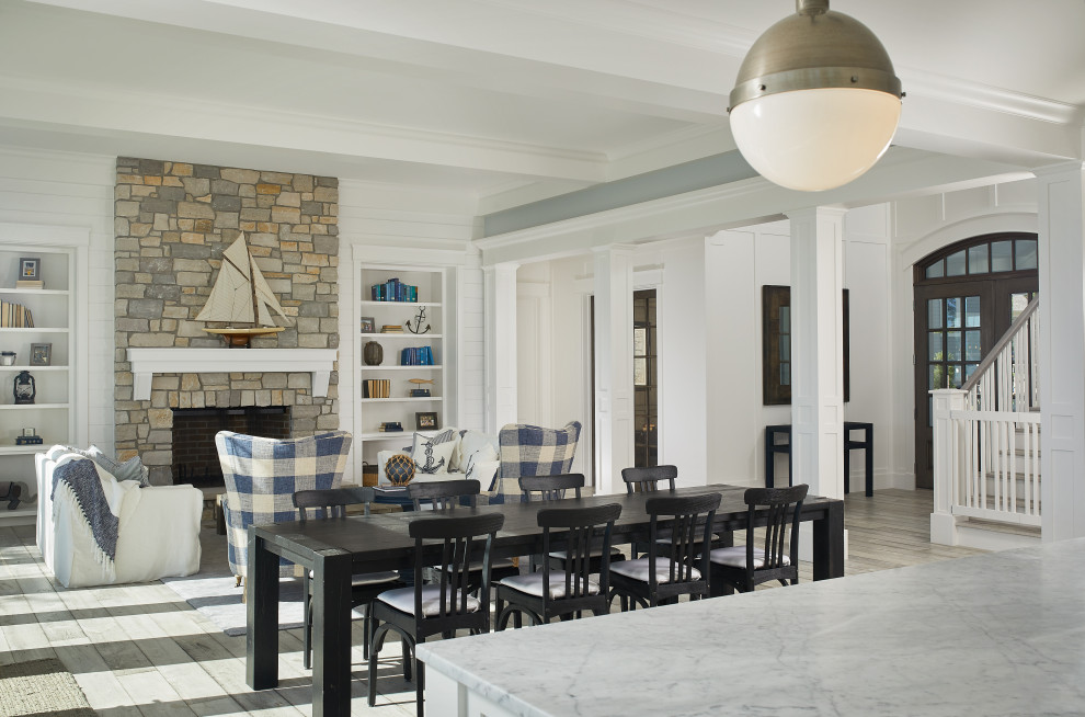 Beach style medium tone wood floor, brown floor, coffered ceiling and wall paneling great room photo in Grand Rapids with gray walls, a standard fireplace and a stone fireplace
