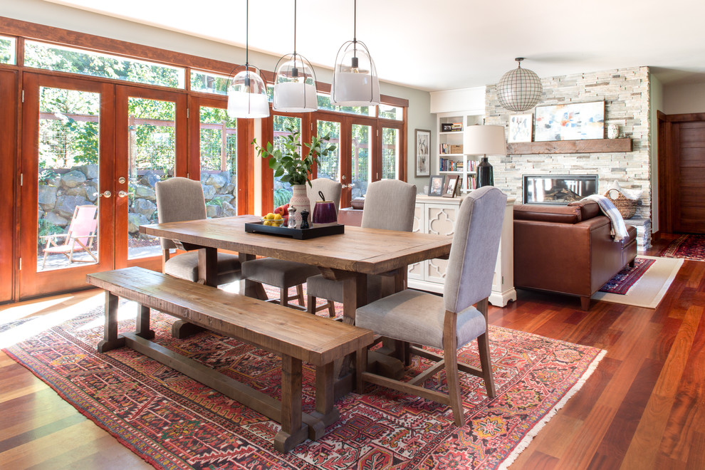 Cette image montre une salle à manger ouverte sur le salon traditionnelle avec un mur gris, parquet foncé et un sol marron.