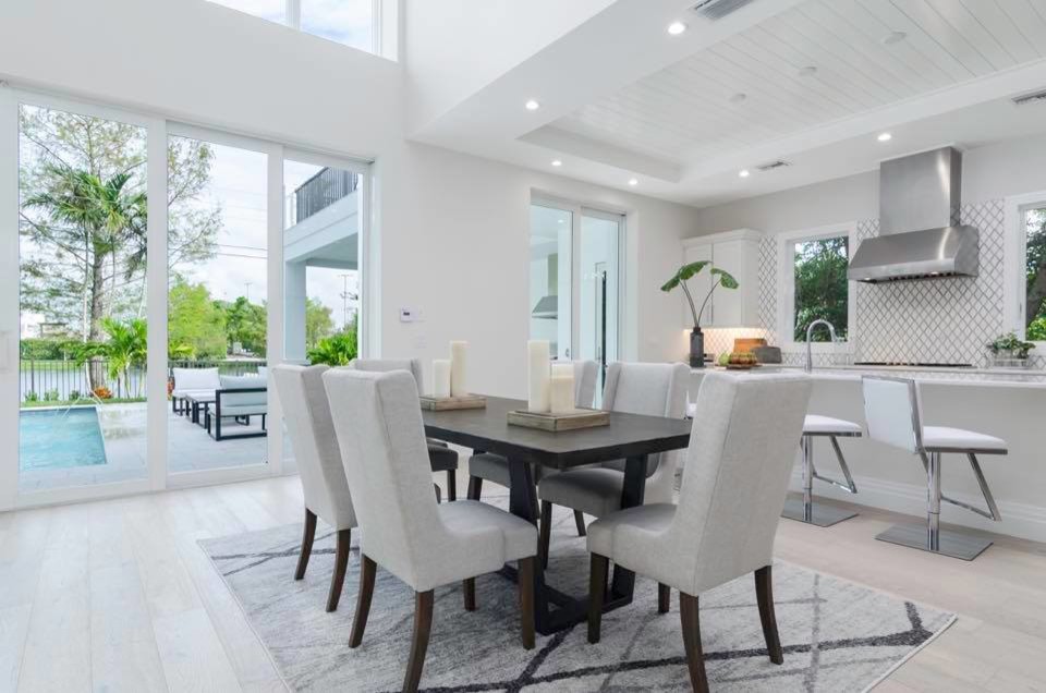 Great room - mid-sized contemporary light wood floor and gray floor great room idea in Miami with white walls, a standard fireplace and a stone fireplace