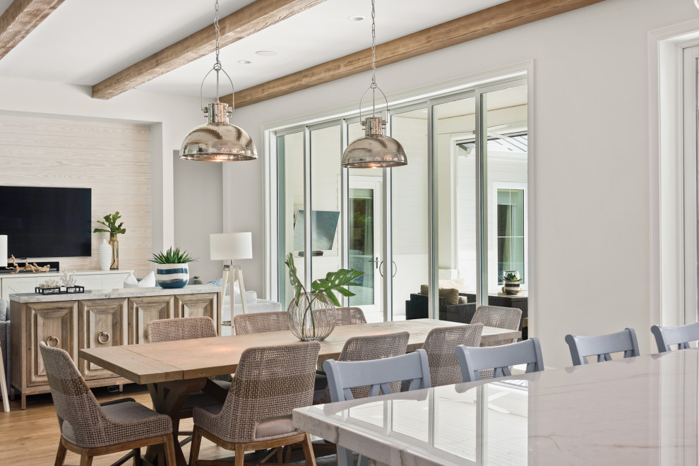 Immagine di una grande sala da pranzo aperta verso la cucina stile marinaro con pareti bianche, pavimento in gres porcellanato e pavimento marrone
