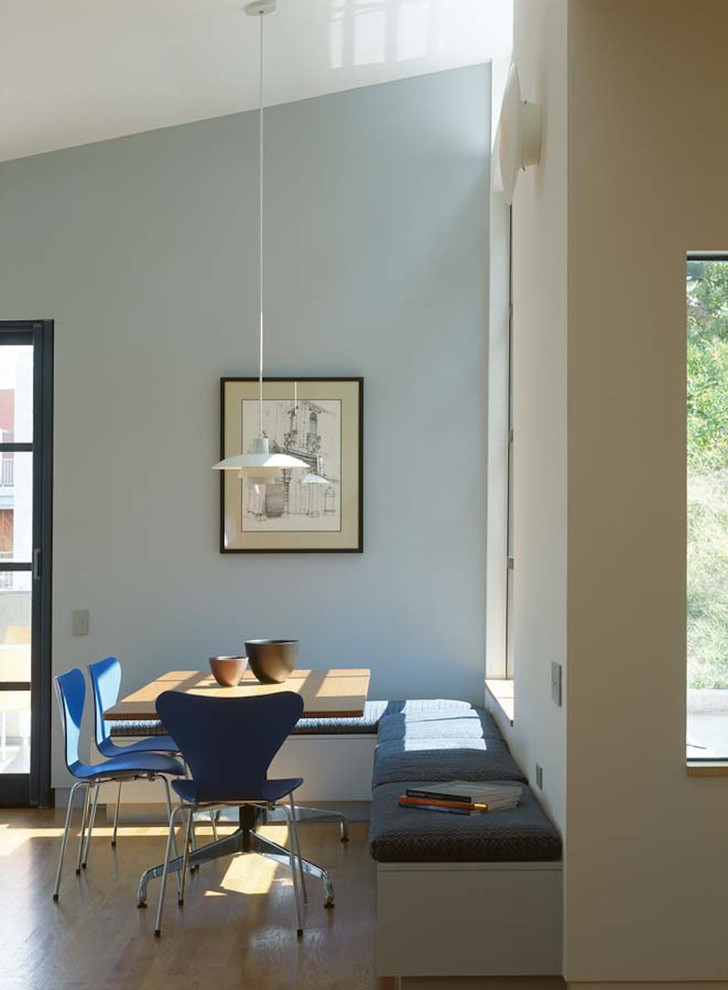 Diseño de comedor minimalista con paredes grises y suelo de madera en tonos medios