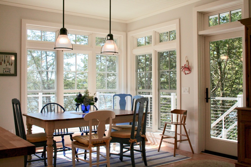 Ispirazione per una sala da pranzo aperta verso il soggiorno stile marino di medie dimensioni con pareti bianche, pavimento in legno massello medio e pavimento marrone