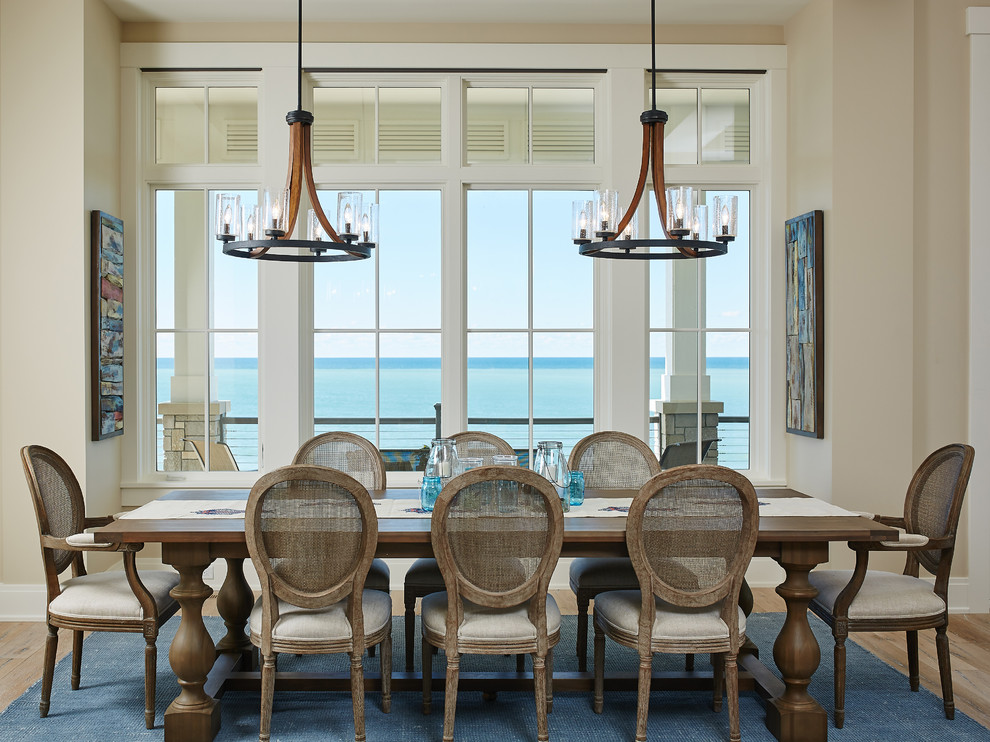 Ispirazione per una sala da pranzo stile marino con pareti beige e parquet chiaro
