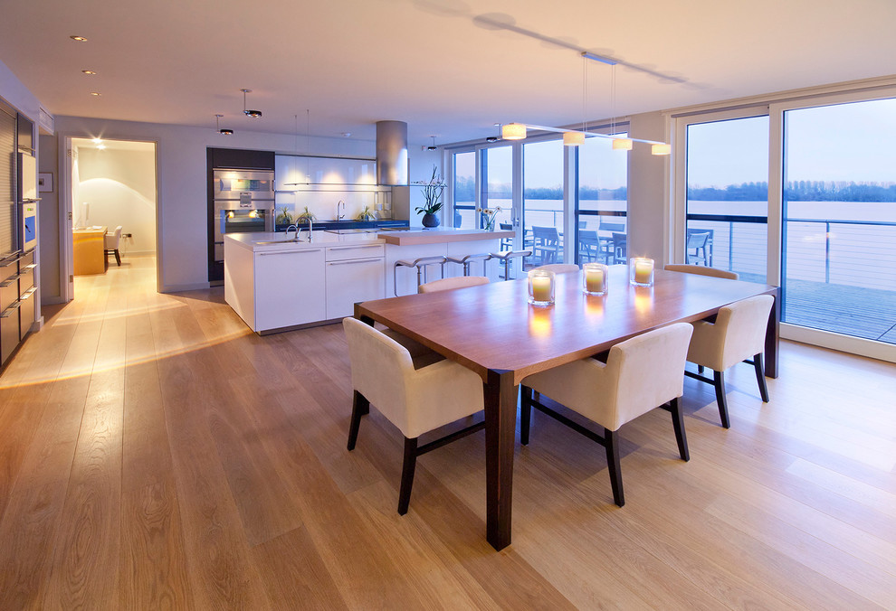 Inspiration for a large contemporary open plan dining room in Surrey with medium hardwood flooring.