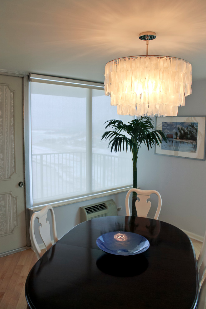 Exemple d'une salle à manger ouverte sur le salon bord de mer de taille moyenne avec un mur blanc et parquet clair.