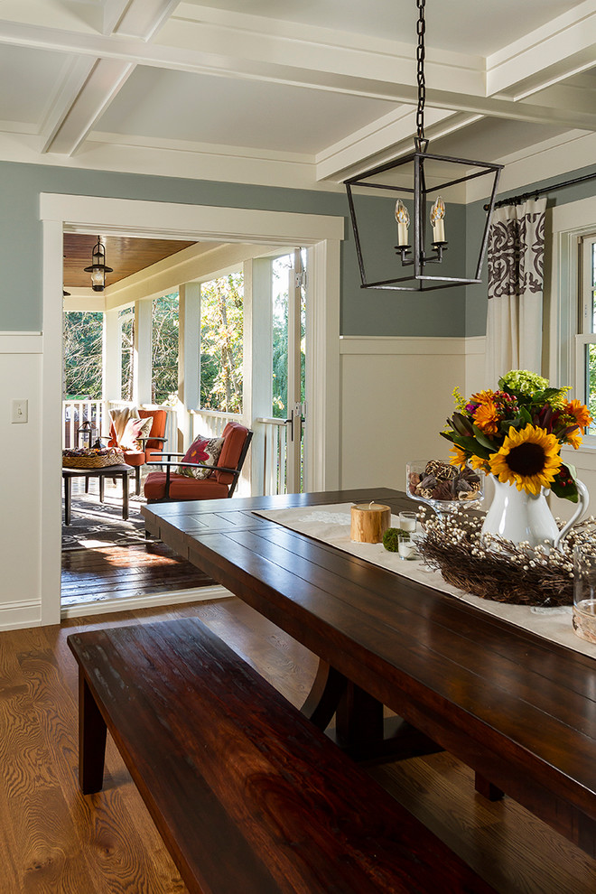 Foto di una sala da pranzo aperta verso la cucina tradizionale di medie dimensioni con pareti blu e pavimento in legno massello medio