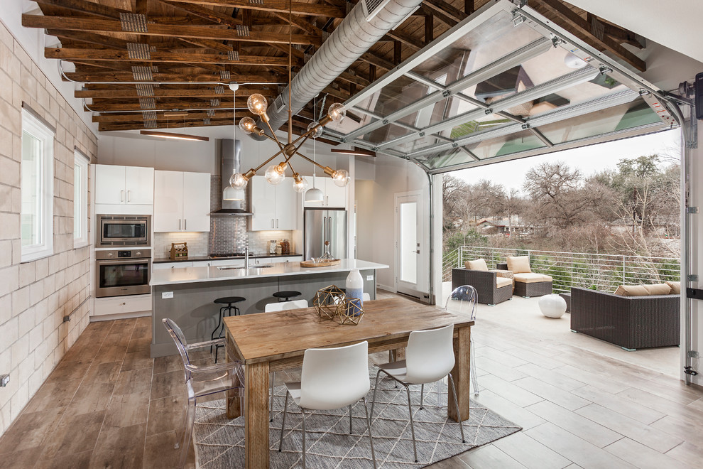 Esempio di una sala da pranzo aperta verso la cucina design con pareti grigie e pavimento marrone