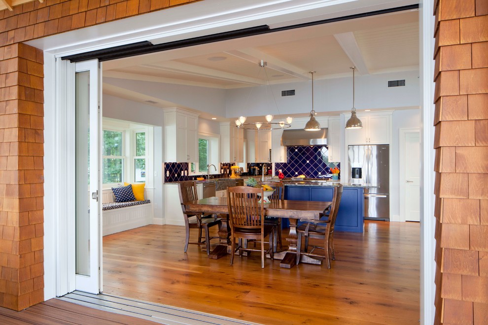Ispirazione per una sala da pranzo aperta verso la cucina stile marino con pavimento in legno massello medio e pareti grigie