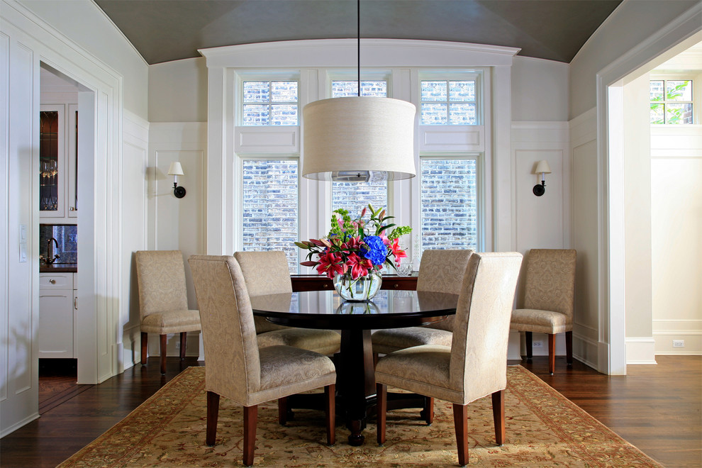This is an example of an expansive traditional enclosed dining room in Chicago with beige walls and dark hardwood flooring.