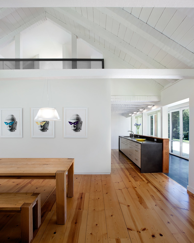 Idee per una sala da pranzo aperta verso la cucina design di medie dimensioni con pavimento in legno massello medio e pareti bianche