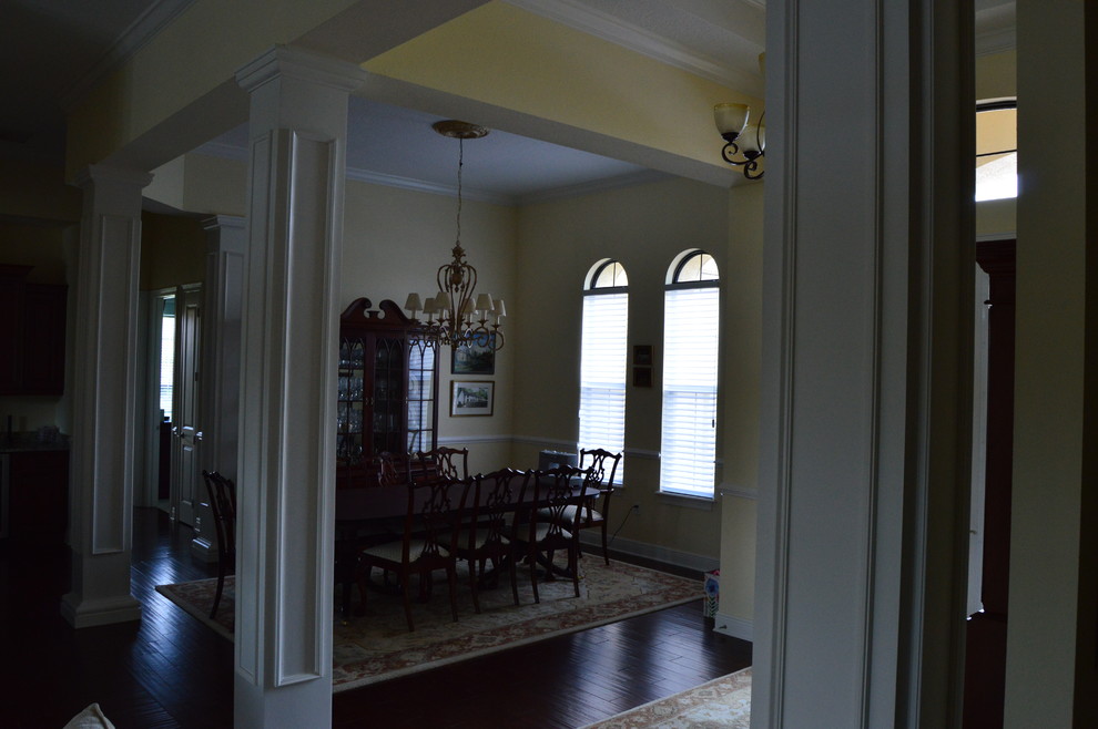 Medium sized classic enclosed dining room in Tampa with yellow walls, vinyl flooring and no fireplace.