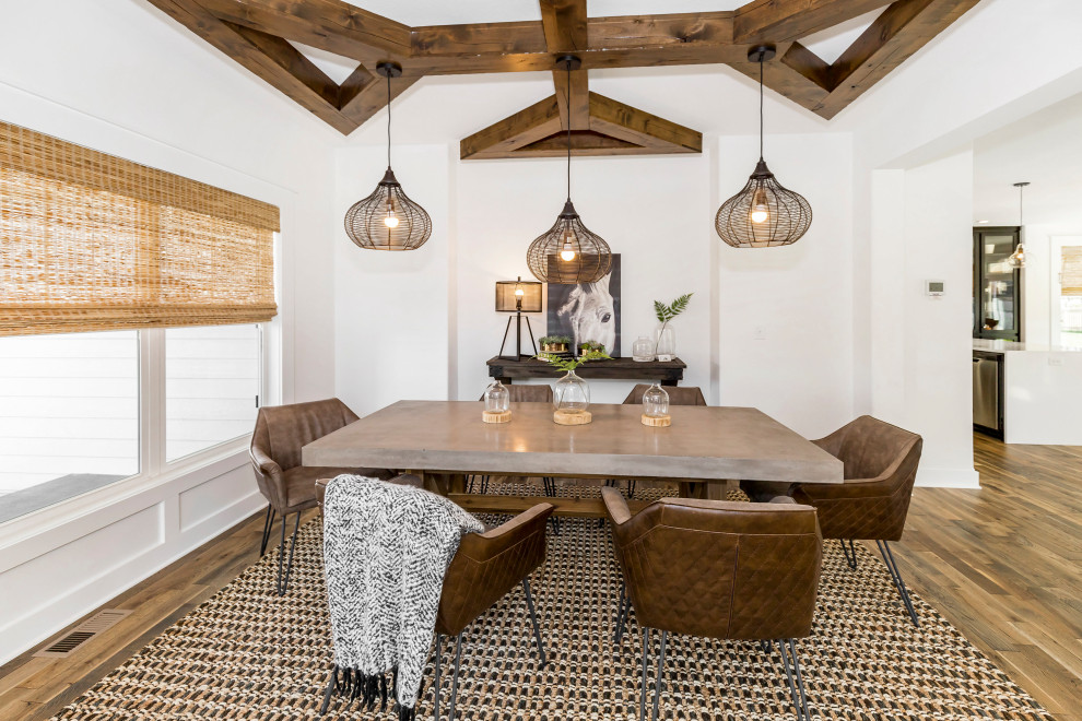 Foto di una sala da pranzo aperta verso il soggiorno country di medie dimensioni con pareti bianche, pavimento in legno massello medio e pavimento marrone