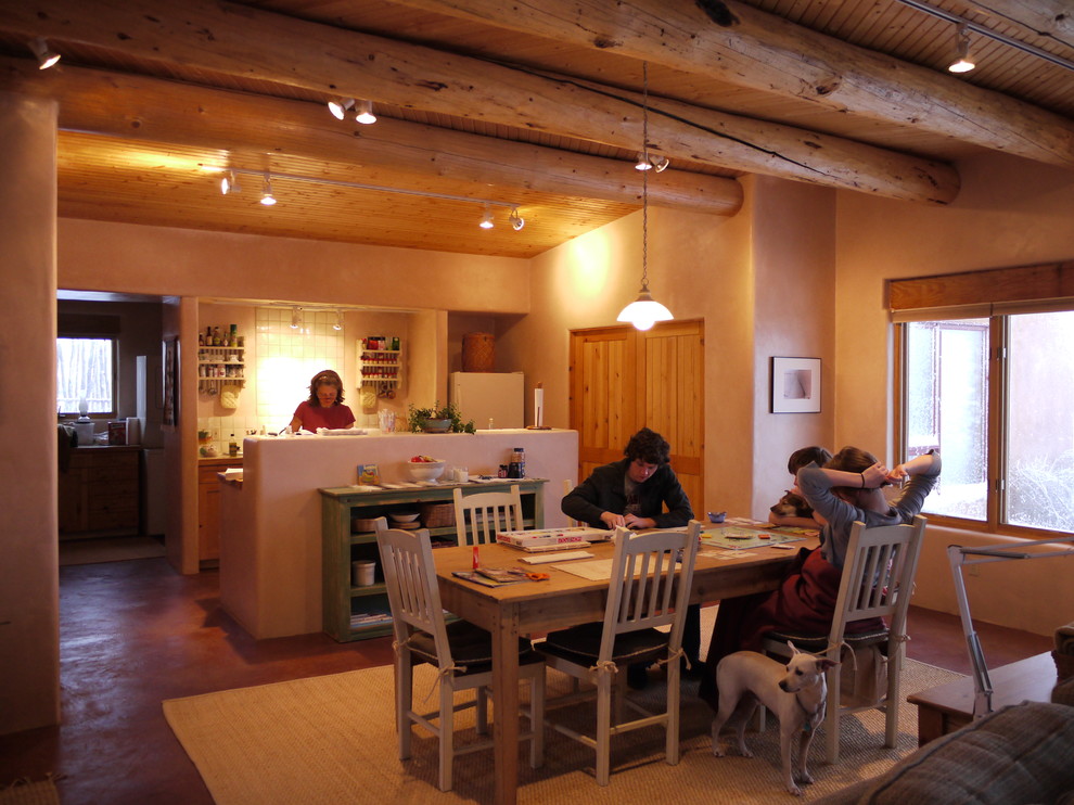 Esempio di una sala da pranzo aperta verso la cucina tradizionale di medie dimensioni con pareti beige, pavimento in cemento e nessun camino