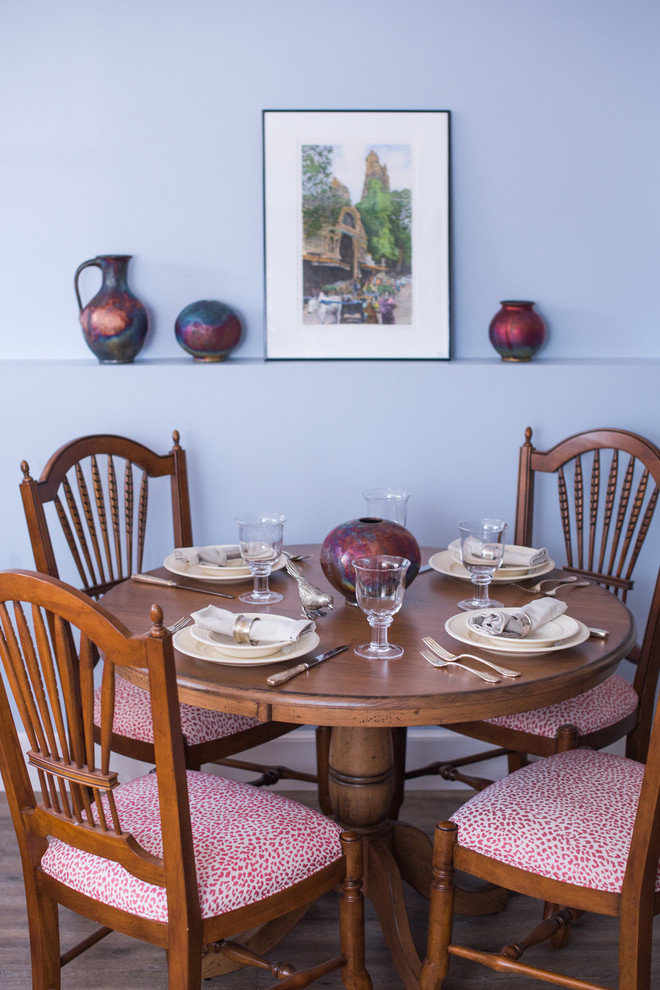 Cette image montre une salle à manger ouverte sur le salon bohème de taille moyenne avec un mur bleu, parquet clair et aucune cheminée.