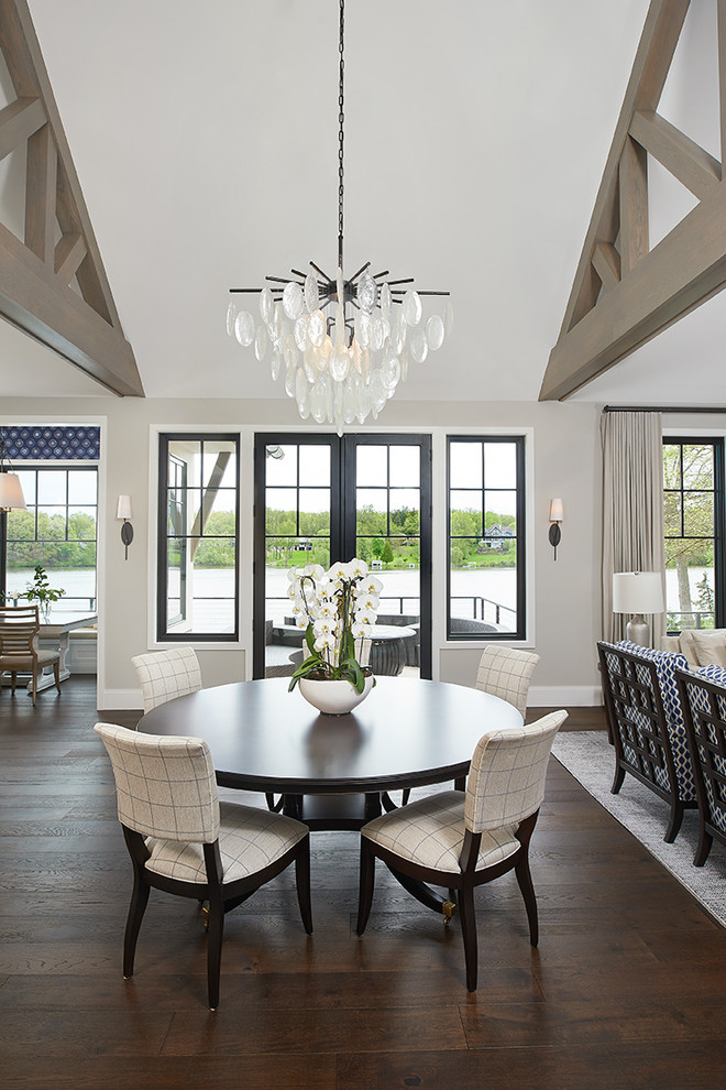 Foto di una sala da pranzo aperta verso la cucina classica con parquet scuro, pavimento marrone, pareti grigie, soffitto a volta e carta da parati
