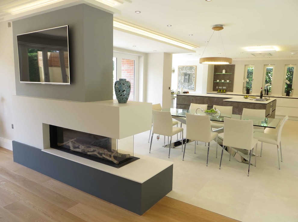 Inspiration for a medium sized modern open plan dining room in Seattle with a two-sided fireplace, white walls, white floors, concrete flooring and a concrete fireplace surround.