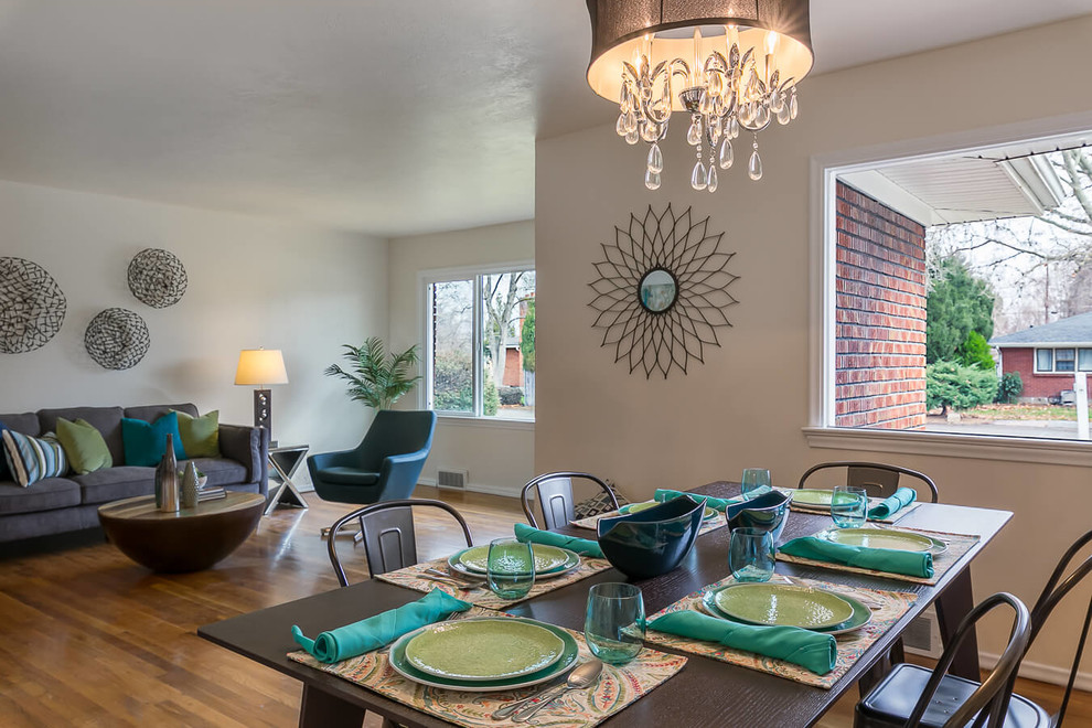 This is an example of a medium sized midcentury open plan dining room in Boise with beige walls, medium hardwood flooring, a standard fireplace and a tiled fireplace surround.