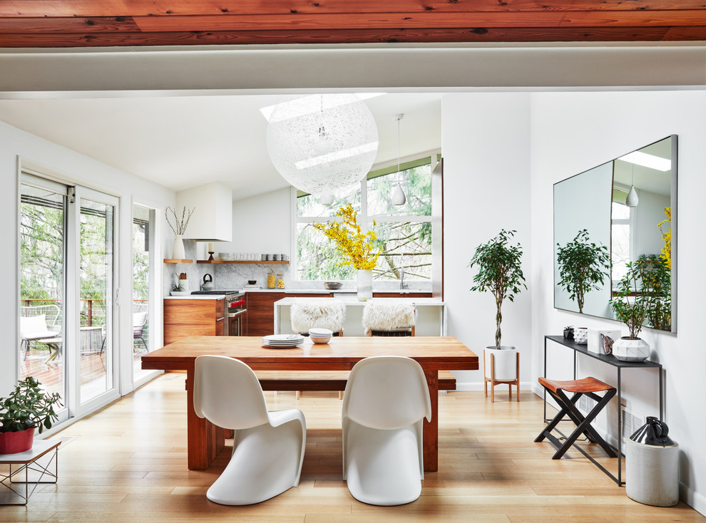 Idee per una grande sala da pranzo aperta verso la cucina contemporanea con pareti bianche, pavimento in legno massello medio e pavimento marrone