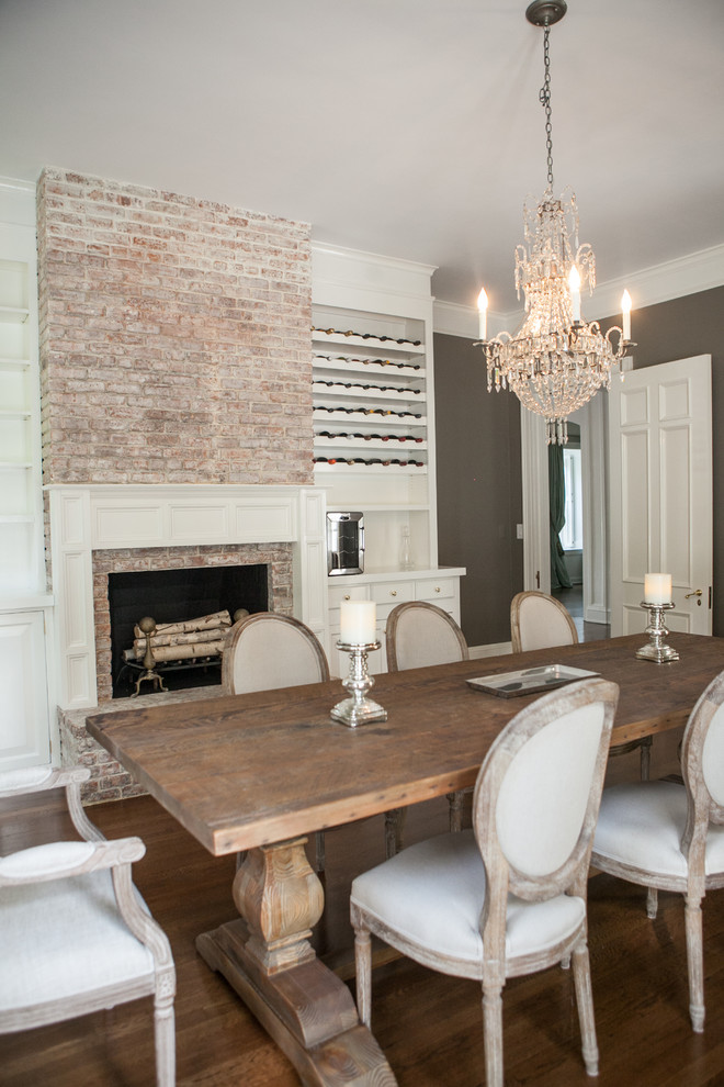 Example of a huge classic medium tone wood floor enclosed dining room design in New York with gray walls, a standard fireplace and a brick fireplace