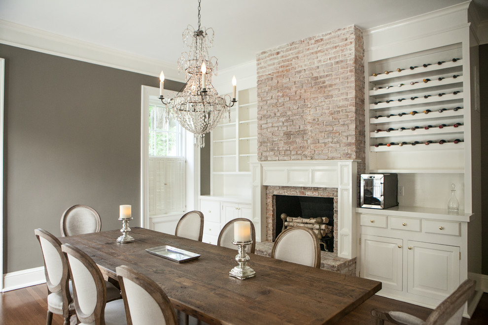 Enclosed dining room - huge traditional medium tone wood floor enclosed dining room idea in New York with gray walls, a standard fireplace and a brick fireplace