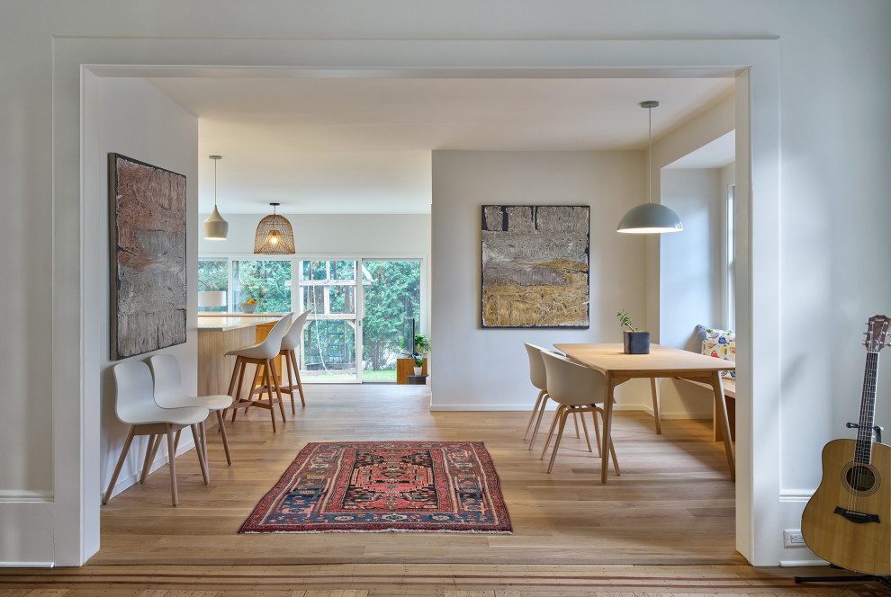 Ispirazione per una sala da pranzo aperta verso la cucina scandinava di medie dimensioni con pareti bianche e parquet chiaro