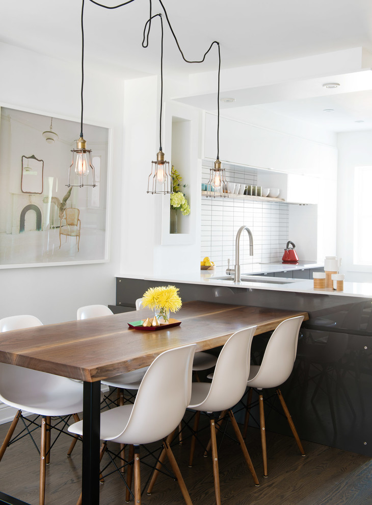 Cette photo montre une salle à manger ouverte sur la cuisine tendance avec parquet foncé et un sol marron.