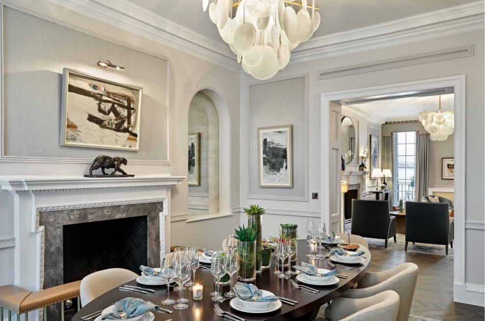 Photo of a medium sized classic enclosed dining room in London with a standard fireplace, grey walls, dark hardwood flooring, a stone fireplace surround, brown floors and wainscoting.