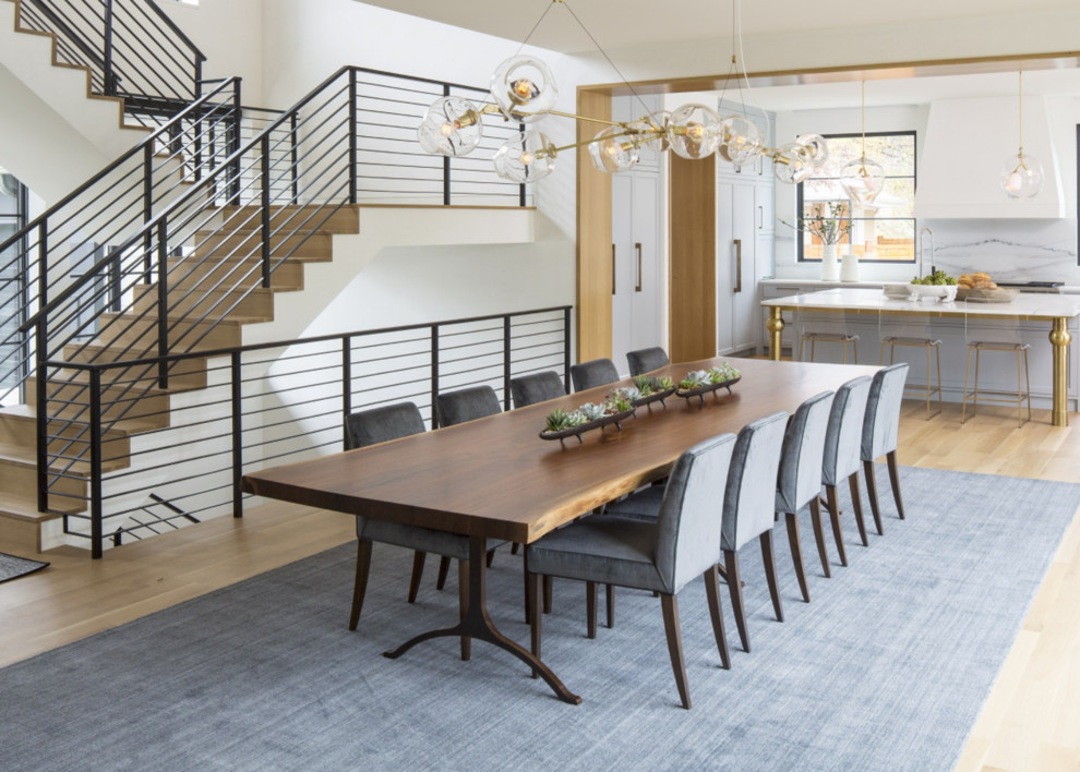 Idee per una sala da pranzo aperta verso il soggiorno minimal con pareti bianche, parquet chiaro e pavimento marrone