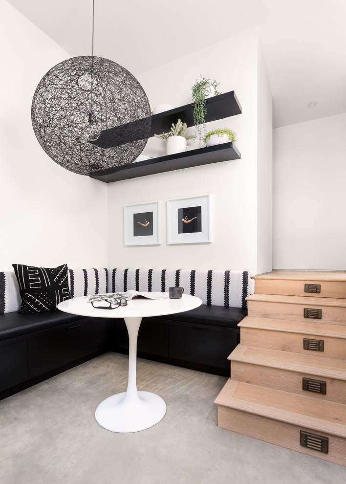 Esempio di una sala da pranzo aperta verso il soggiorno minimal di medie dimensioni con pareti bianche, pavimento in cemento e pavimento beige
