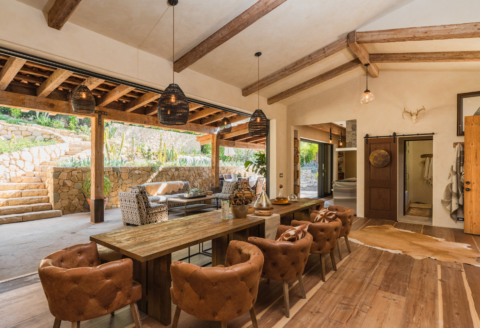 This is an example of a mediterranean dining room in Santa Barbara with beige walls, dark hardwood flooring and brown floors.