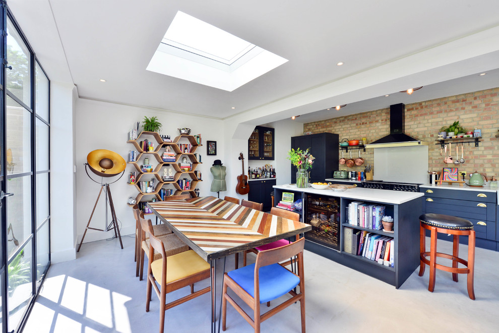 Design ideas for a large eclectic kitchen/dining room in London with white walls, concrete flooring, grey floors and feature lighting.