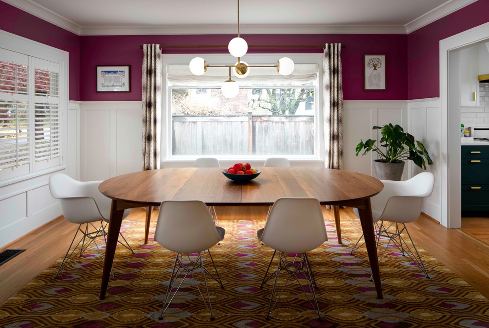Cette photo montre une salle à manger chic fermée avec un mur rose, un sol en bois brun et un sol bleu.