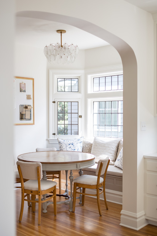 Imagen de comedor clásico con paredes blancas, suelo marrón y suelo de madera en tonos medios