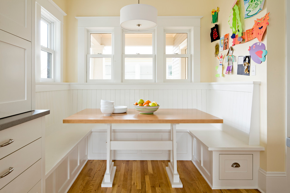 Kleine Klassische Wohnküche ohne Kamin mit gelber Wandfarbe, braunem Holzboden und braunem Boden in Portland
