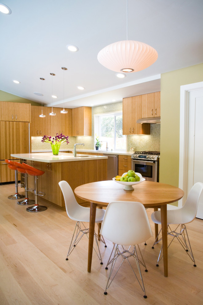 Immagine di una sala da pranzo aperta verso la cucina minimalista di medie dimensioni con pareti verdi, parquet chiaro, nessun camino e pavimento beige