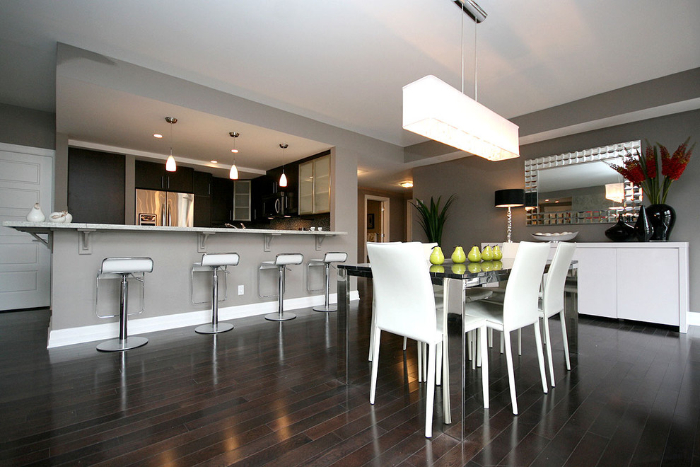 Exemple d'une salle à manger ouverte sur la cuisine tendance avec un mur gris et parquet foncé.