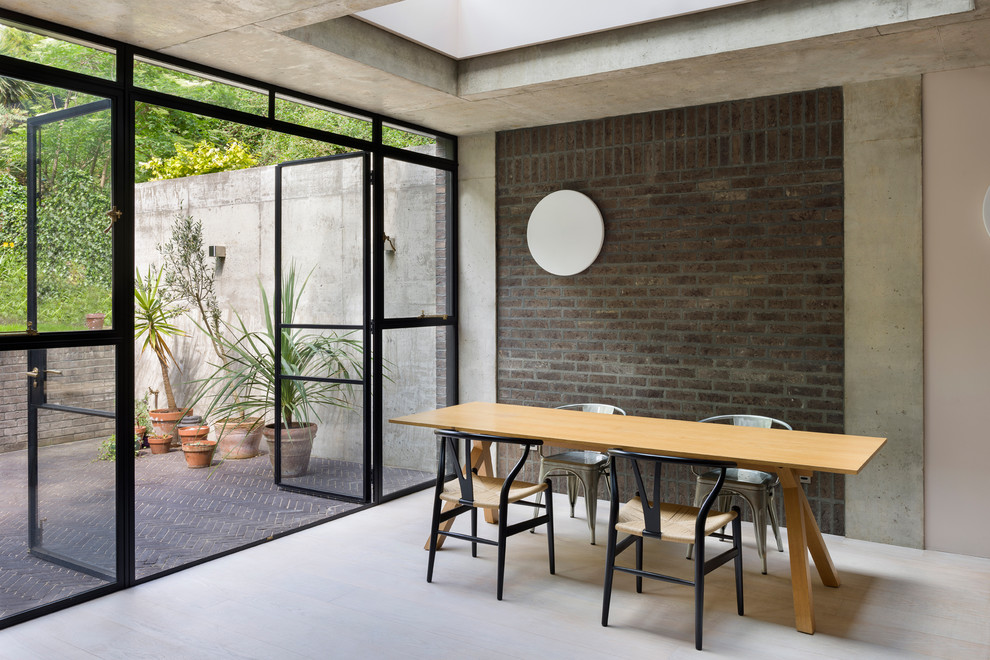 Foto di una sala da pranzo aperta verso la cucina industriale di medie dimensioni con pareti grigie, pavimento in legno massello medio e pavimento bianco