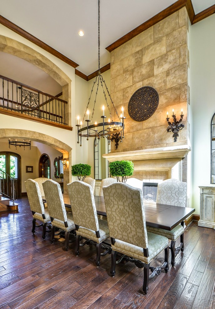 Example of a large tuscan dark wood floor and brown floor enclosed dining room design in Nashville with beige walls, a standard fireplace and a tile fireplace