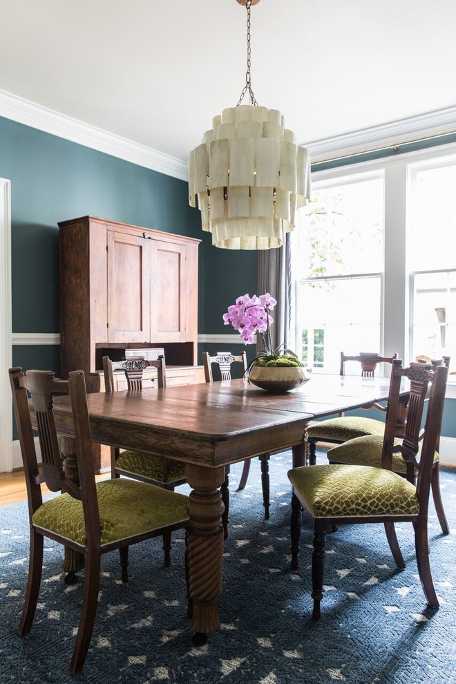 Classic enclosed dining room in Charlotte with green walls, medium hardwood flooring and orange floors.