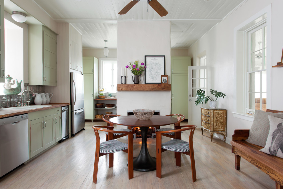Aménagement d'une salle à manger ouverte sur la cuisine campagne de taille moyenne avec un mur blanc, parquet clair, une cheminée standard, un manteau de cheminée en plâtre, un sol beige et éclairage.