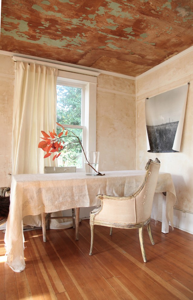 Modelo de comedor romántico con paredes beige, suelo de madera en tonos medios y cortinas